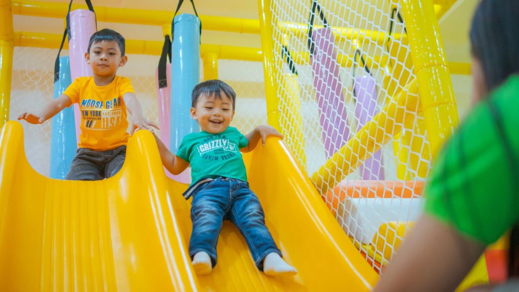 Children sliding down a slide in an indoor playground